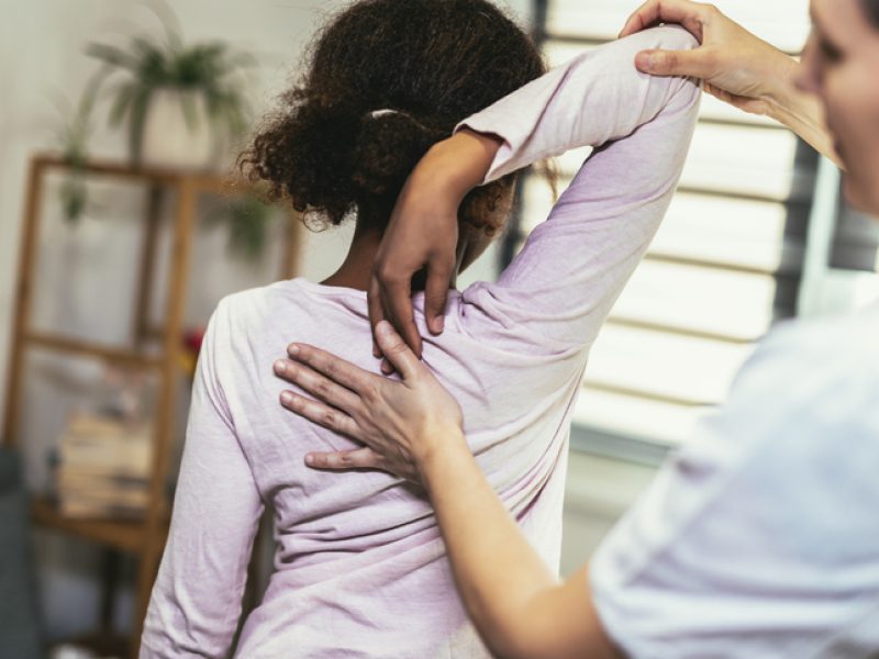 Teen Girl having chiropractic back adjustment. Osteopathy, Physiotherapy, Kinesiology. Bad posture correction